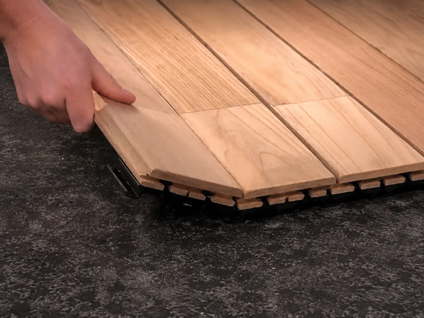 Pose à la main d'une lame de terrasse clipsable sur son support